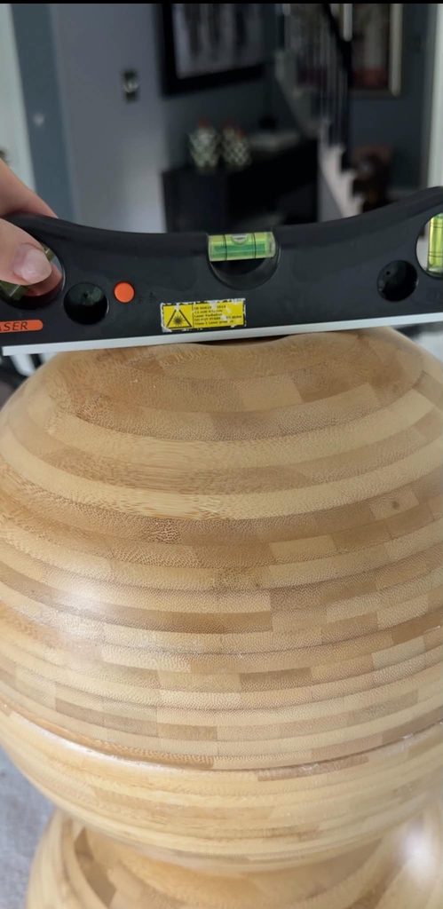 Checking the level of a DIY side table creation using IKEA salad bowls.