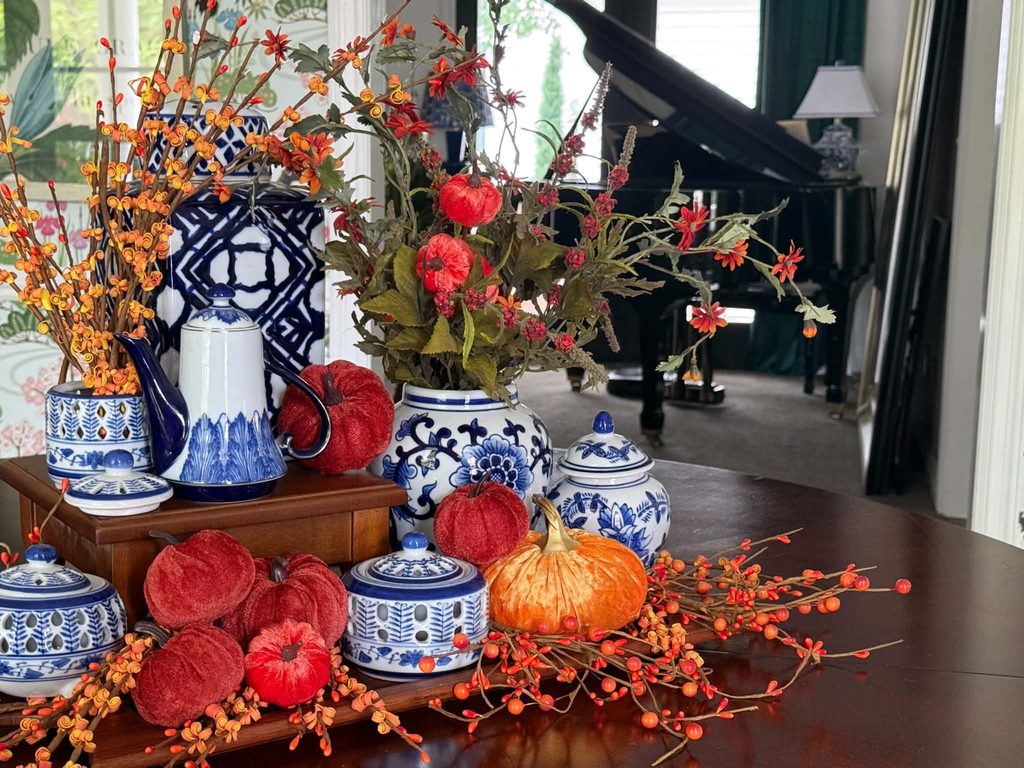 A fall tray decorated with pumpkins and ceramic chinoiserie with a piano in the background.
