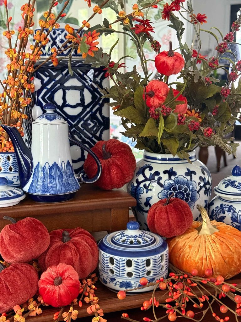 A tray display filled with blue and white chinoiserie and orange pumpkins.