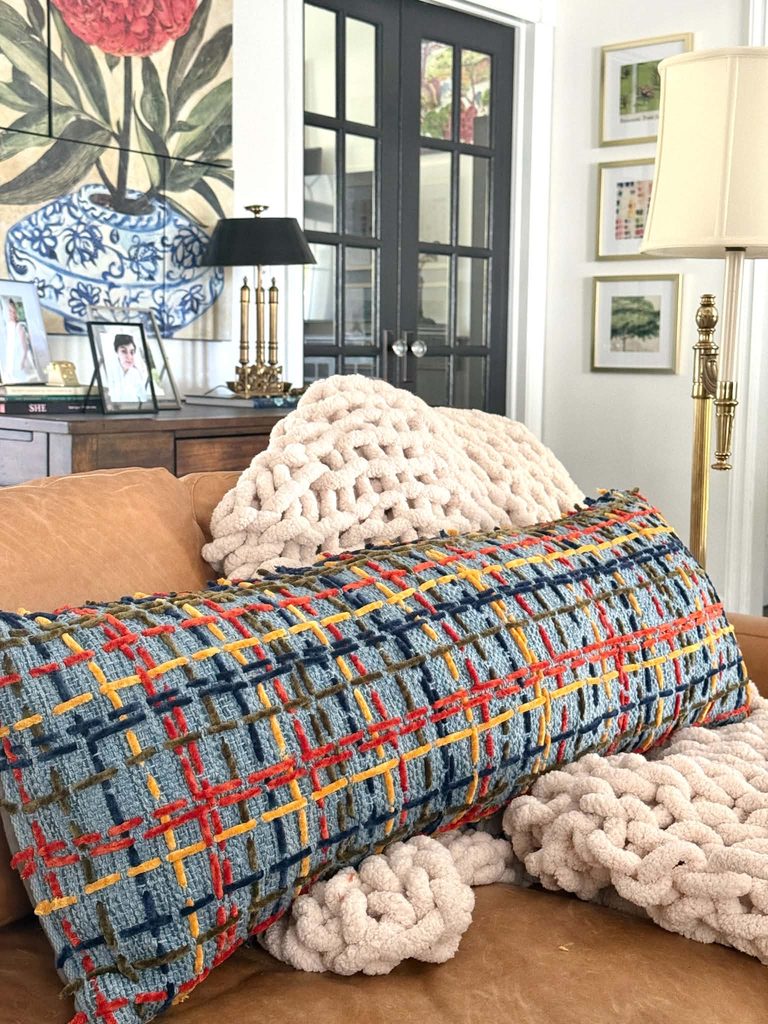 A throw pillow makeover using yarn to decorate with a plaid pattern.
