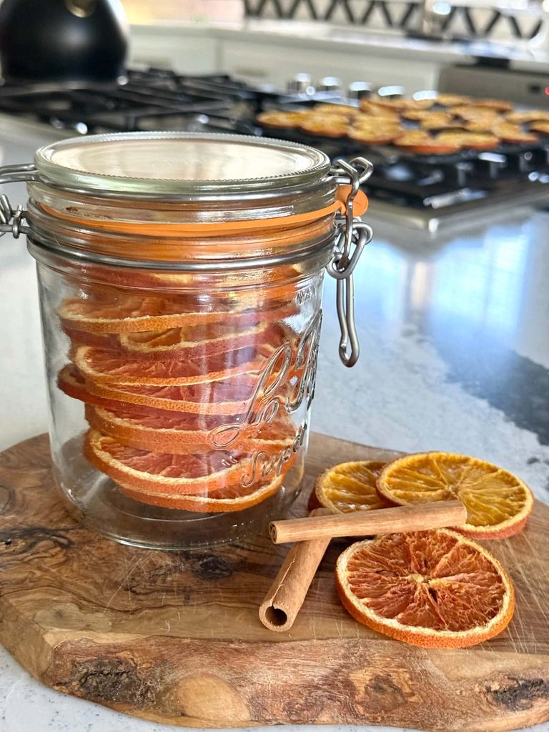 Storing dried orange slices in a sealed glass jar.