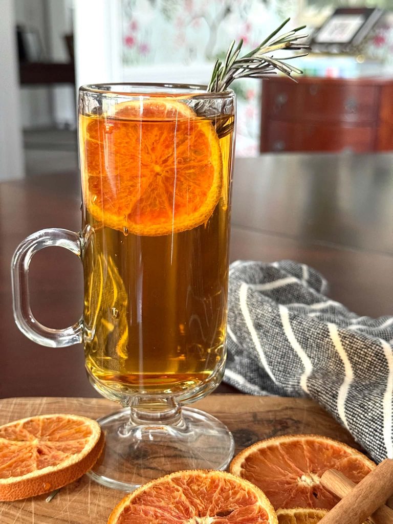 A dried orange slice in a cup of cider.