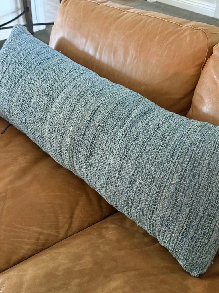 A worn pillow that is the base for a decorative throw pillow makeover.