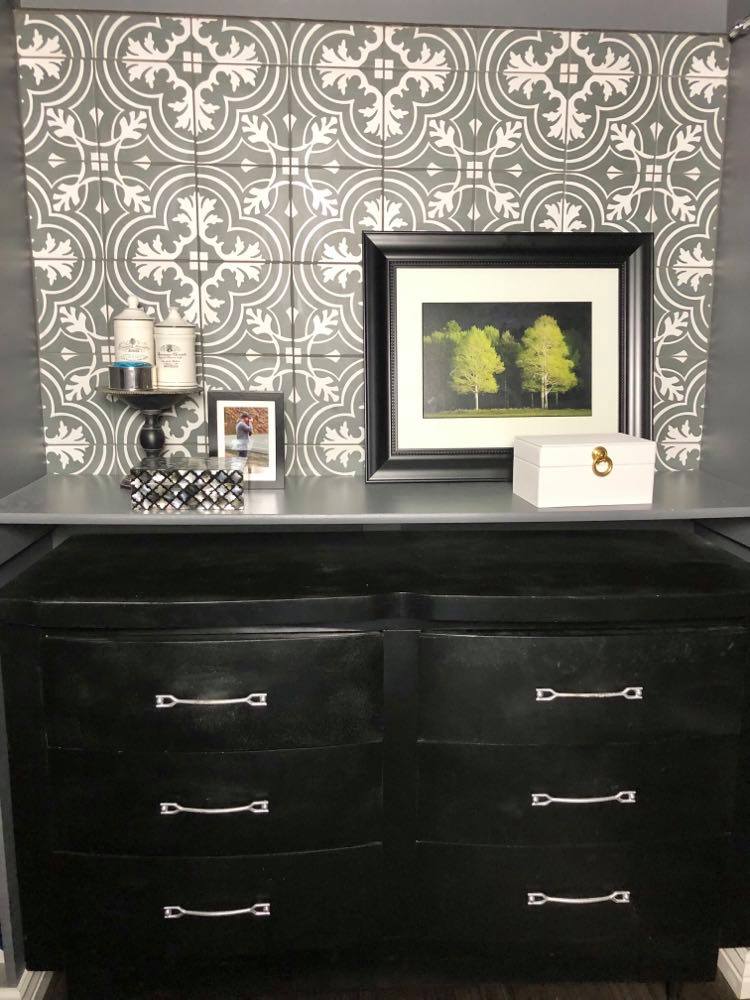 A repurposed vanity in a small walk-in closet decorated with a jewelry box and wall art.