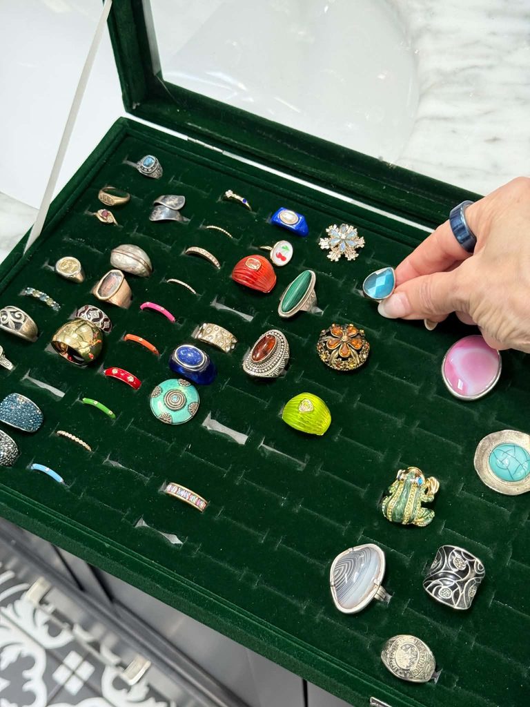 A green velvet tray box storing various rings.